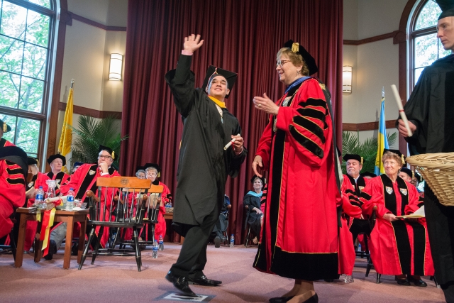 Devan Martinez '18 waves to his friends, family and classmates before receiving his diploma from Sister Carol.