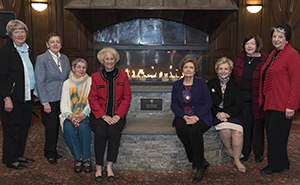 Members of the Class of '66 pose with the fireplace and its new plaque after the dedication.