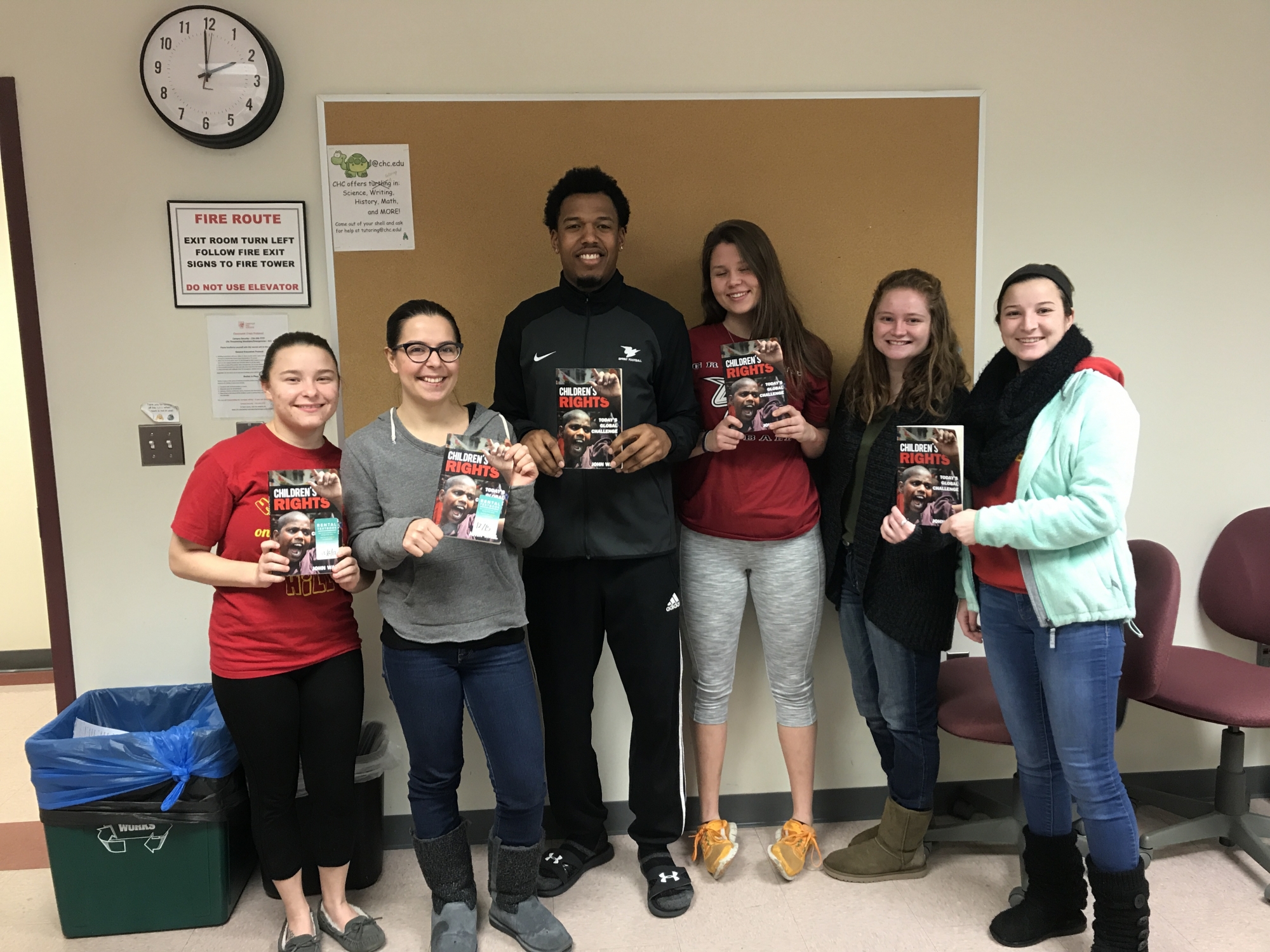 Students in Sara Kitchen's class pose with copies of John Wall's book after he met with the class to discuss his work.