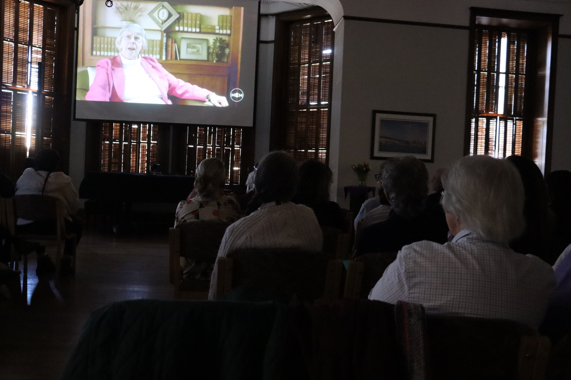 individuals in a room watching a film