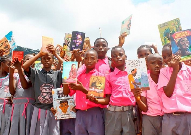 Children in Sierra Leone hold books they were given by the Traprock Center for Peace & Justice. (Photo courtesy of the Traprock Center for Peace & Justice)