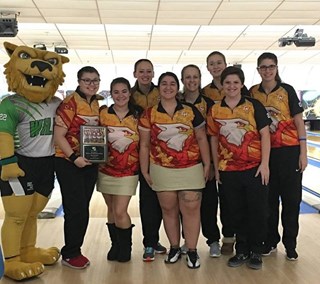Members of the women's bowling team stands with their plaque after finishing in third at the Wildcat Invitational.