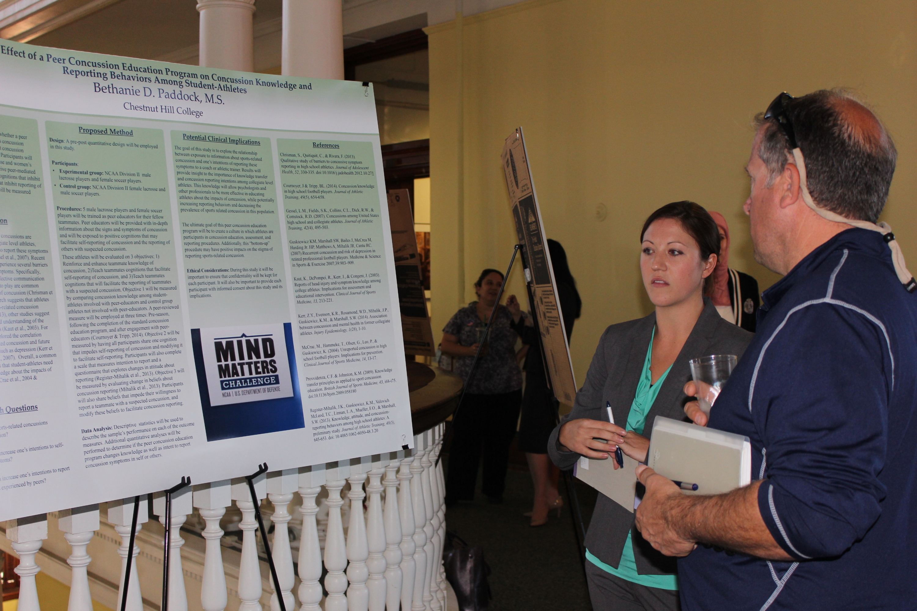 Doctoral student Bethanie Paddock explains her poster presentation about concussion education.