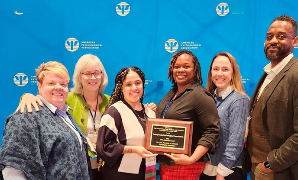 Jade Logan (center, right) and Jayneyshka Ortiz (center, left) accept the SPTA Diversity Award alongside colleagues in the PPA.