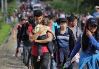 Hundreds of Honduran migrants walking down road