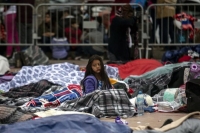 Migrant kids amongst blankets 