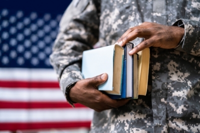 hands holding books in front of US flag
