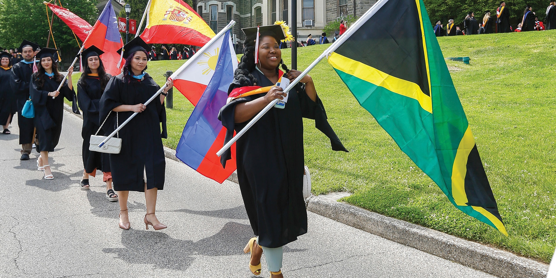 students carrying flags at commencement ceremony
