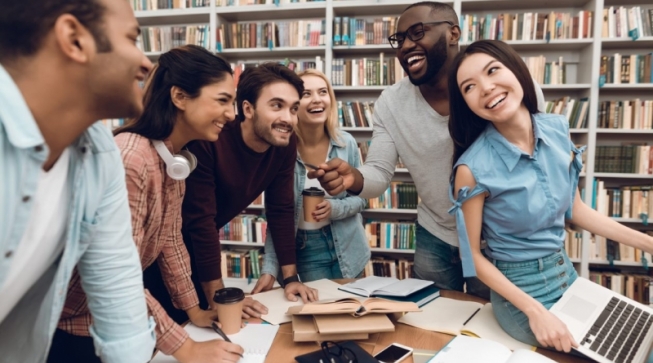 Six students smiling together in library