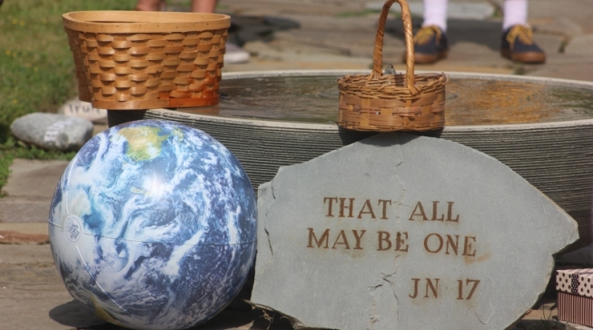 globe next to plaque that reads, "that all may be one"