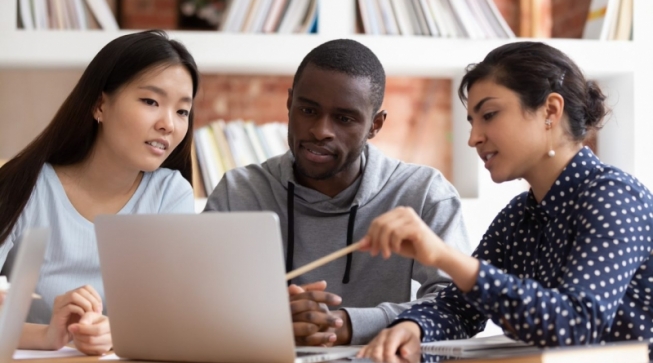 Two students and a financial aid counselor looking at computer