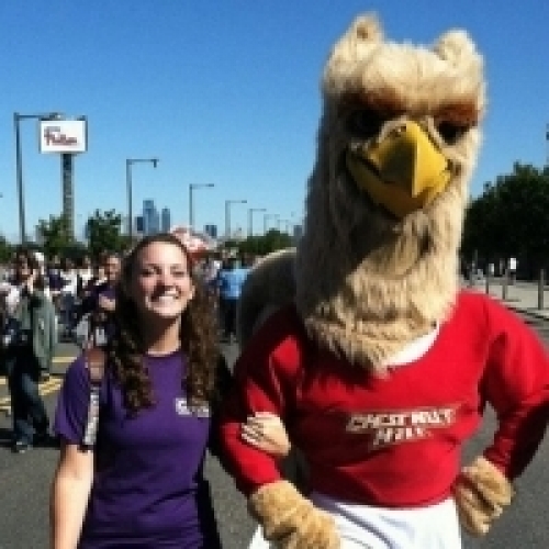 Female student walking with Griffin mascot
