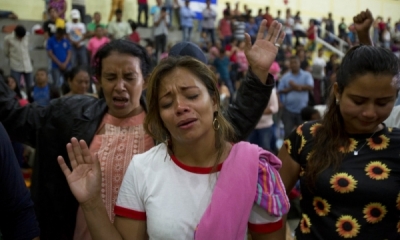 Group of Honduran women crying and praying