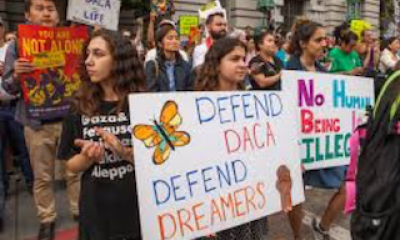 Protesters holding sign saying 'Defend DACA. Defend DREAMers.'