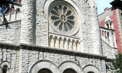 Front of Gothic revival church next to row houses