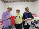 Fran Wasserman, founder/director of The Baby Bureau (left), along with volunteers, organize “baby bundles” of clothing.