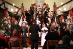 group of people singing in front of Christmas decorations