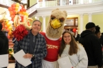 family poses with mascot inside college building