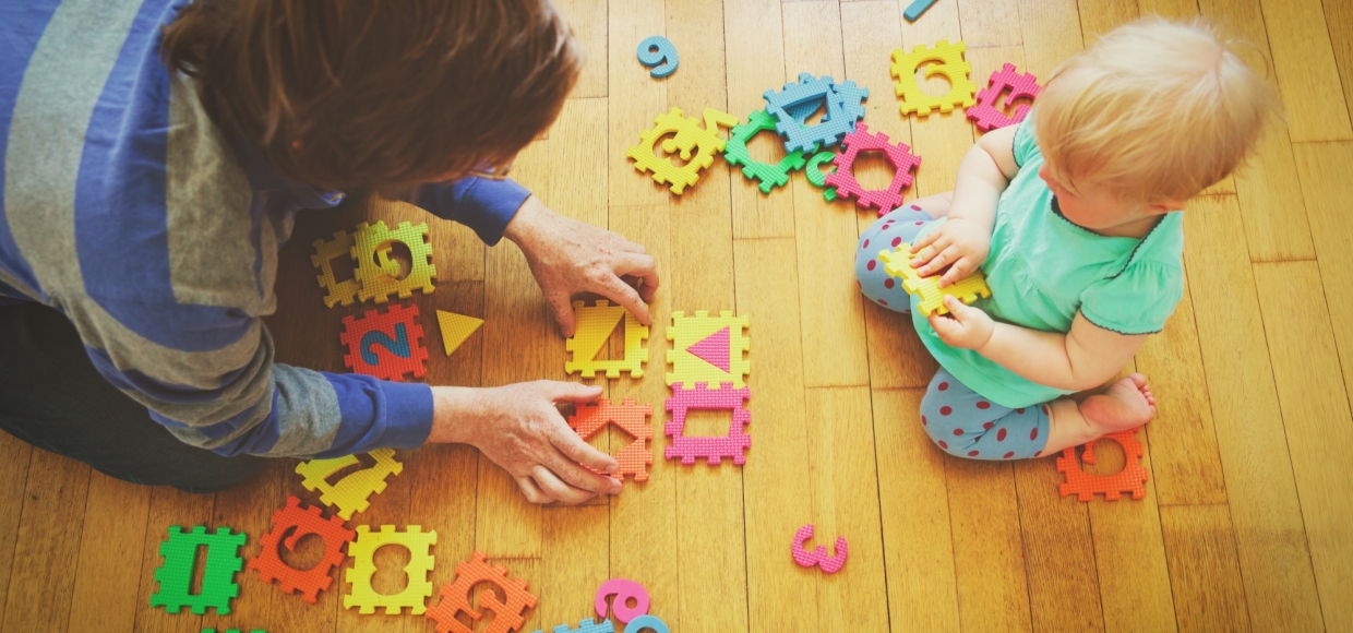 Adult and child playing with rubber number toys