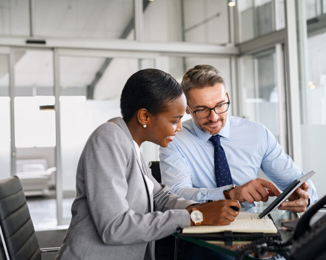 Business partners working on digital tablet in modern office stock photo