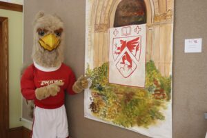 Griffin mascot posed with art