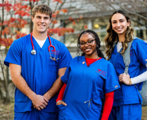 3 nursing students in blue scrubs