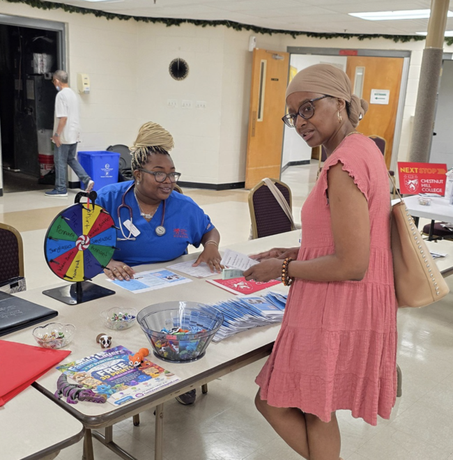 nursing student working with a patient at community health fair