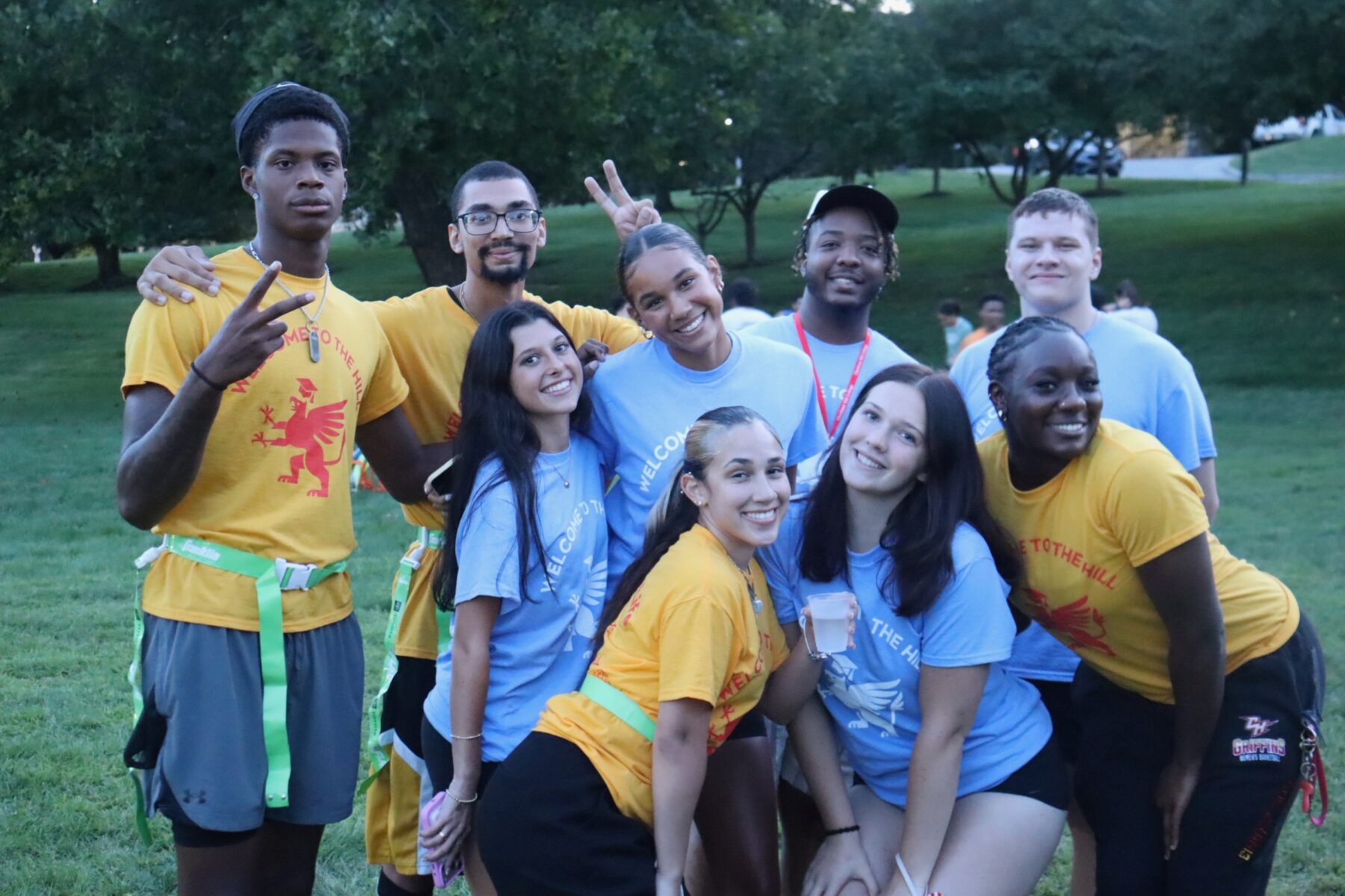 group of college students posing for a photo outside at night during orientation weekend
